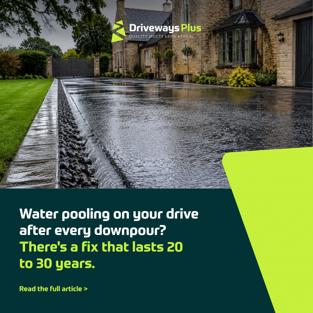 A modern stone house with a wet driveway, reflecting the sky and surrounded by green grass and plants. Water pools along the edge, highlighting drainage issues—an important consideration for electric vehicle driveways after rainfall. | Driveways Plus
