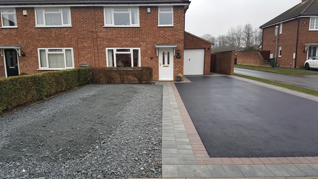Driveway half stripped to compacted sub-base and half finished in fresh tarmac, showing resurfacing against replacement